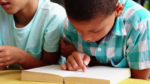 Schoolkids reading book in library at school