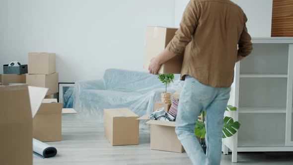 Slow Motion of Handsome Middle Eastern Guy Bringing Cardboard Boxes to New House