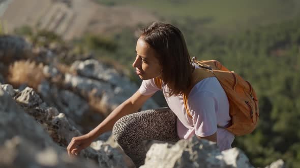 Slow Motion Young Woman Hiker Rock Climber Climbs Up on Cliff on Mountain Over Beautiful Sea Coast