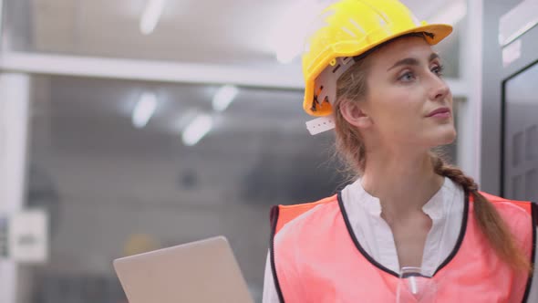 Caucasian female industrial worker checking and repairing machine