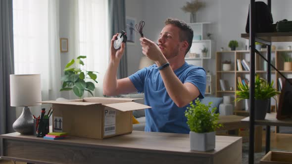 Handsome Young Man Takes a Computer Mouse Out of a Cardboard Box