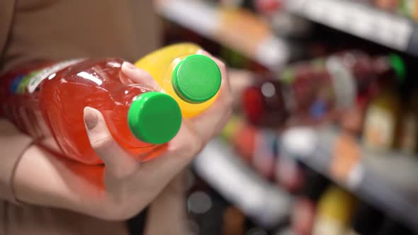 The Girl Chooses a More Natural Juice in the Store