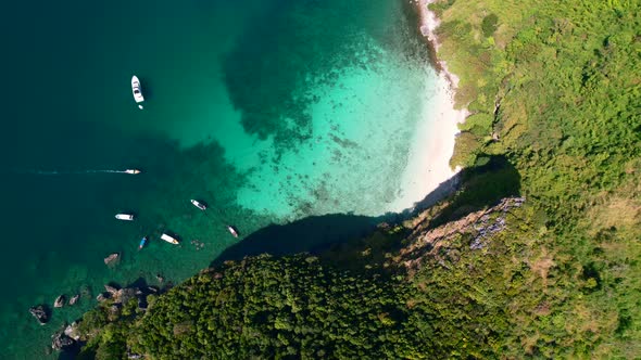 aerial drone top down view zooming in clockwise onto a turquoise blue coral reef and pristine white