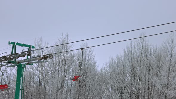 View of the Ski Lift Against the Background of a Mountain Forest and Gray Sky in the Carpathians