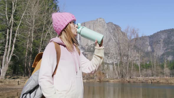 Woman Drinks Water Relaxing Outdoors in Mountain Park on Sunny Day Yosemite