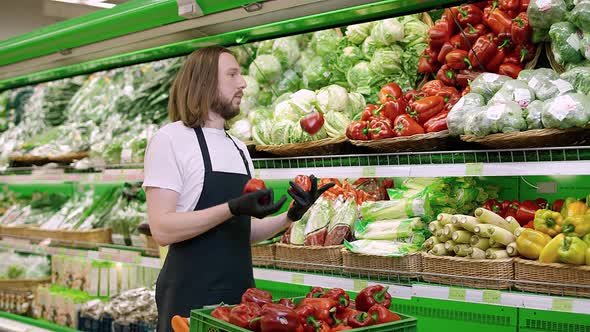 Man Replenishes Products on the Shelves Juggles Red Pepper Fruits Young Man Puts Paprika on a Shelf