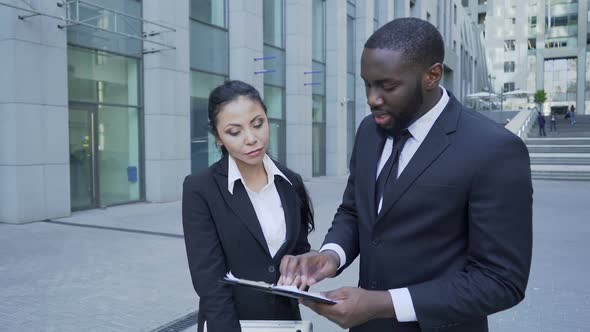 Boss Commenting on Files to Personal Assistant Near Office, Important Documents