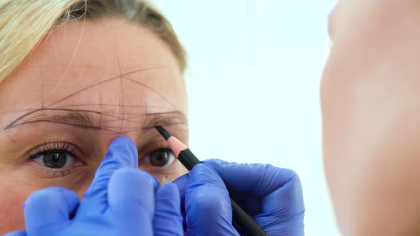 Cosmetologist Preparing Woman for Eyebrow Microblading Procedure