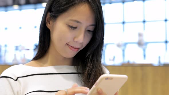 Woman Working on Mobile Phone Inside Coffee Shop