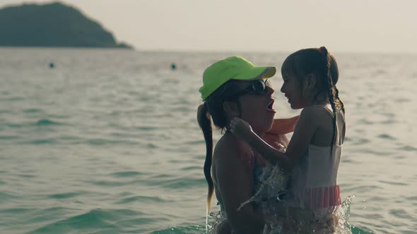 Silhouettes of Mommy and Girl Diving in Calm Ocean Waves