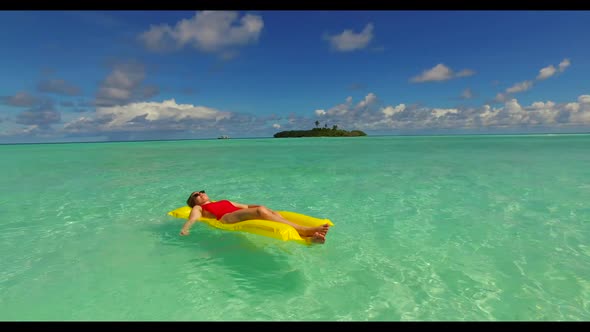 Family of two tan on relaxing sea view beach wildlife by blue green water with white sand background