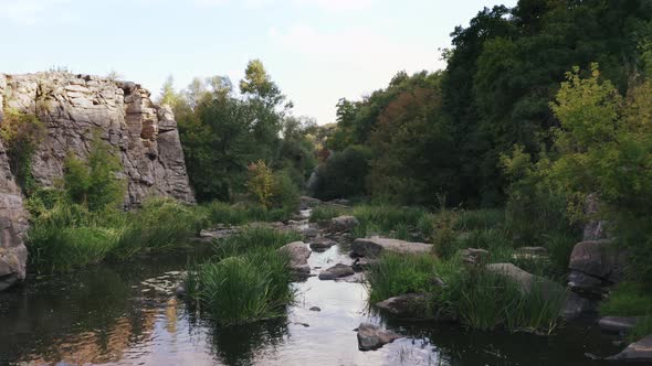 Aerial Shot with Drone Flying Close to the Water Above Rhe Rocks in Canyon During Sunny Day