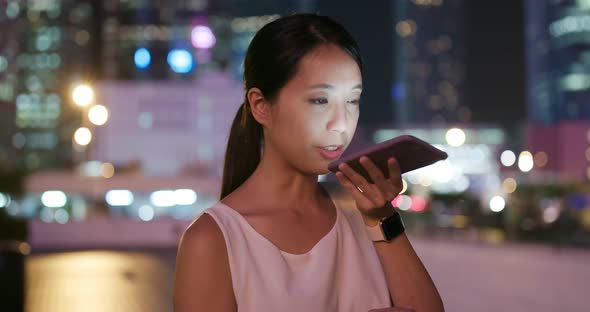 Woman work on mobile phone in city at night