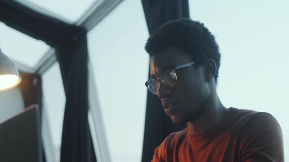 African Man Working on Laptop in Rooftop Office