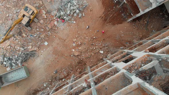 Aerial Overhead Moving Downward View of a Demolition Site with Excavator