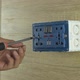 unscrew the screws from the socket in a plastic box on a wooden wall. - VideoHive Item for Sale