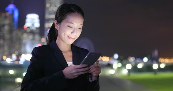 Asian woman use of mobile phone in the city at night 