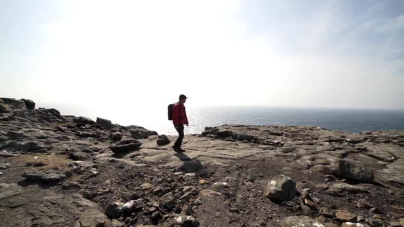 Hiker Walking Over Cliff Tops