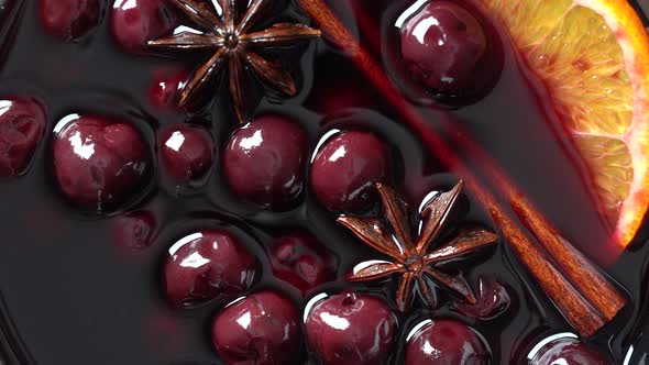 Mulled red cherry wine or punch with slice of orange and anise star and cinnamon