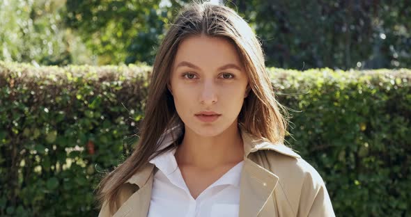 Portrait of Young Attractive Female Who Looking at the Camera on Green Historical Urban Area. Close