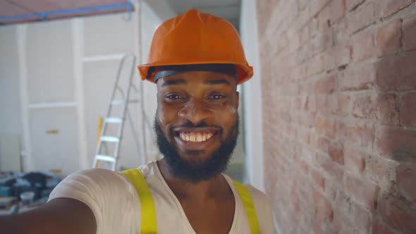 Pov Shot of African Builder in Safety Helmet Taking Selfie Over Construction Site Background