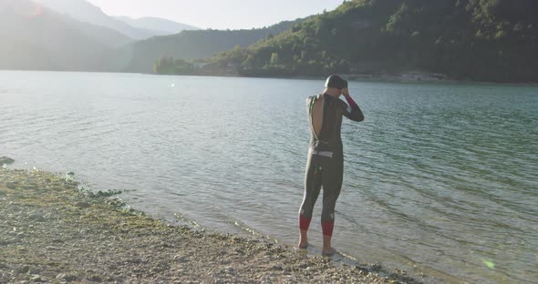 Determined Professional Triathlon Athlete in Wetsuit Start with Swimming Training for Ironman
