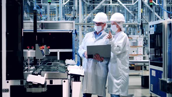 Two Plant Inspectors are Observing Modern Equipment at Work