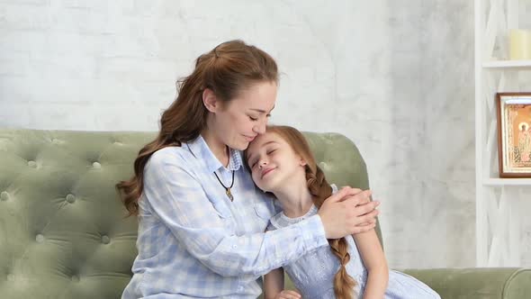 Mother Hugs and Kisses Her Daughter