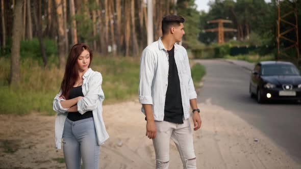 Hopeless Caucasian Millenial Couple Hitchhiking with Cars Passing on Suburban Road