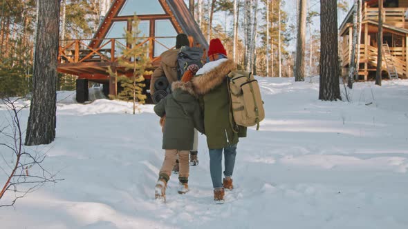 Family of Three Walking Towards Cabin