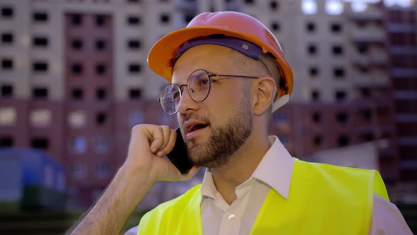 Close Up View of a Young Worker Who Talks on His Phone