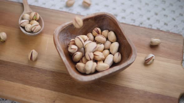 Wooden Bowl With Pistachios On Wooden Board.