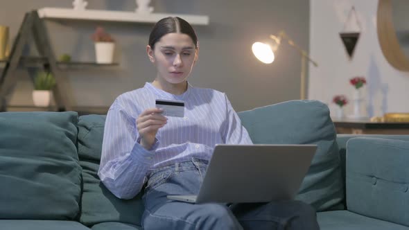 Hispanic Woman with Unsuccessful Online Payment on Laptop on Sofa