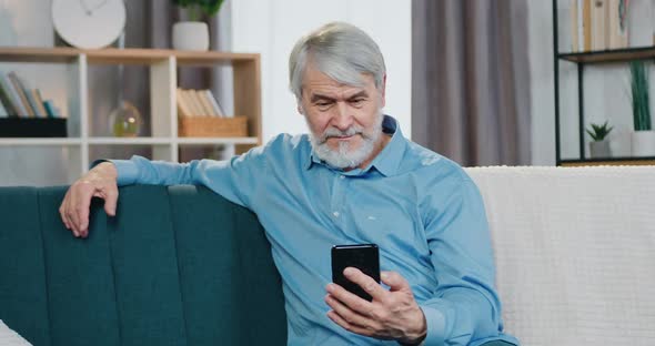 Mature Man Using Modern Smartphone for Video Chat