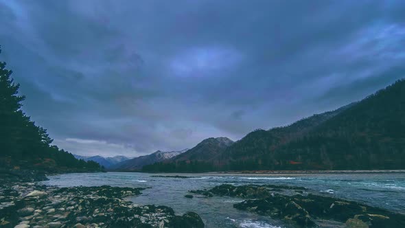 Time Lapse Shot of a River Near Mountain Forest. Huge Rocks and Fast Clouds Movenings.