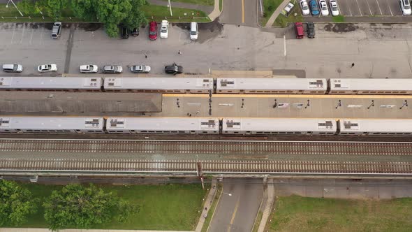 A top down shot directly over two trains at a station. One train is pulling out, the other is stoppe