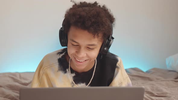 Teenage Boy with Laptop in Bed