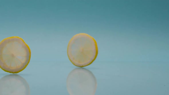 Slow Motion a Lemon Slice Fall on Blue Background Soft Drink with Lemon