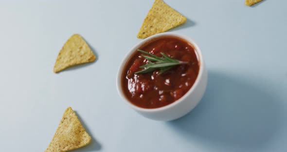 Video of tortilla chips and salsa dip on a grey surface