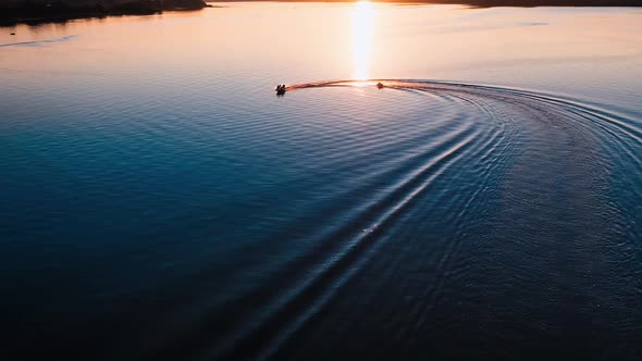 Motion of boats at sunset. Amazing view on the evening river with motor boat leaving paths