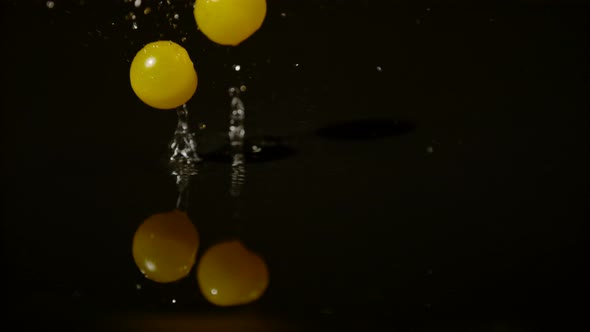 Tomatoes falling on wet surface, Ultra Slow Motion
