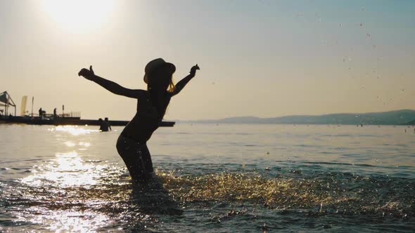 Silhouette of Young Girl Play on Ocean at Sunset, Summer Vacation, Positive Mood