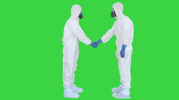 Doctors or Scientists in Hazamat Suits Meet and Shake Hands on a Green Screen, Chroma Key