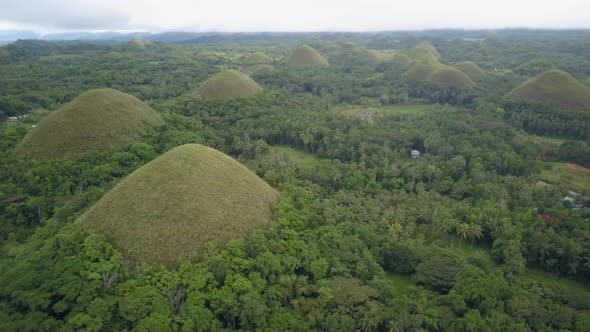 Aerial view of green Chocolate Hills in Bohol, the Philippines. Camera turning slightly while flying