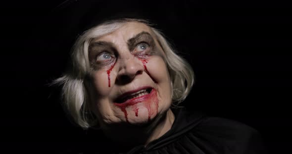 Old Witch Halloween Makeup. Elderly Woman Portrait with Blood on Her Face.