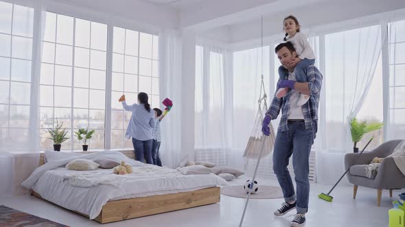 Dad Mopping Floor with Daughter on His Shoulders