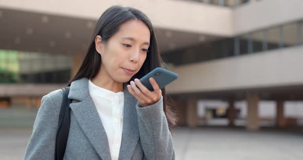 Asian Business woman look at smart phone in city