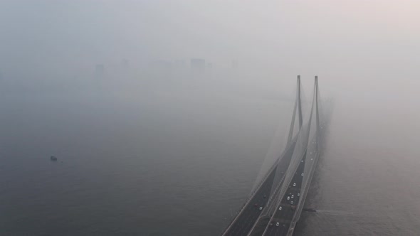 rising drone shot of large suspension bridge bandra worli sealink Mumbai on a hazy day