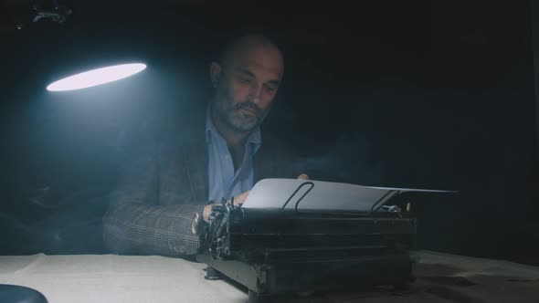 Bearded Stylish Writer Typing on Typewriter. Writer Working on New Book in Office.