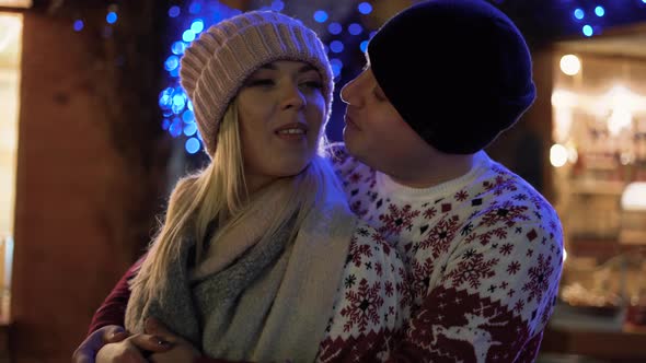 Young Romantic Couple Having Fun and Kissing Outdoors in Winter Christmas